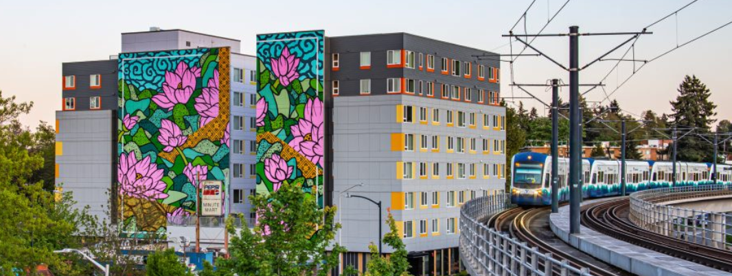 Seattle train passes building and mural of flowers